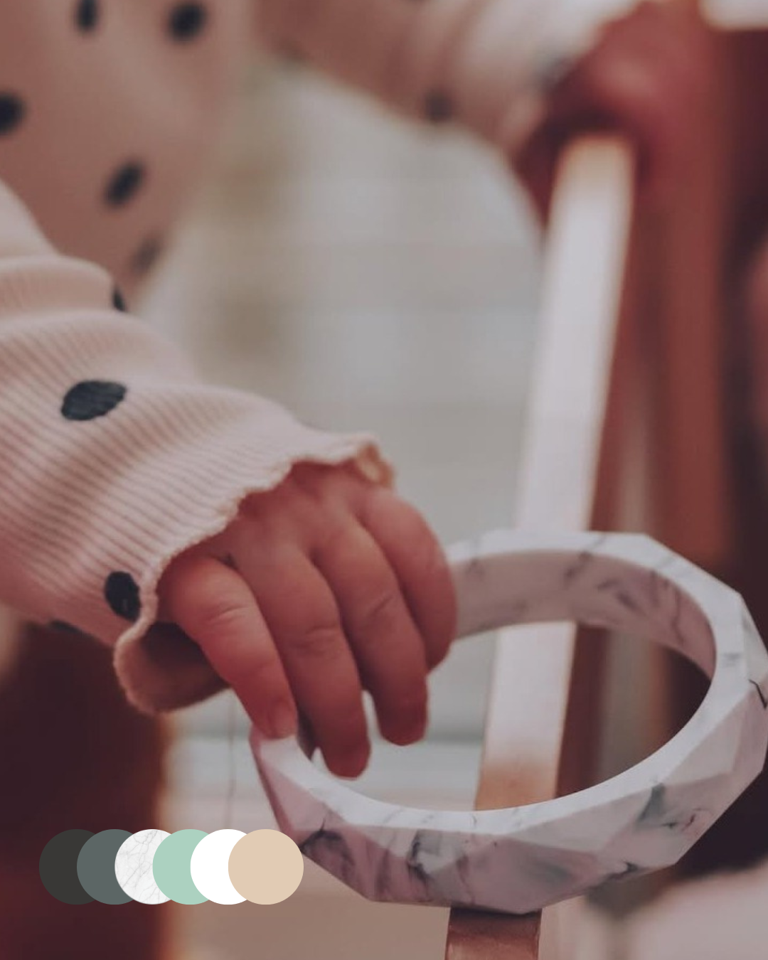 Marble geometric teething bracelet held by child - Blossy mama