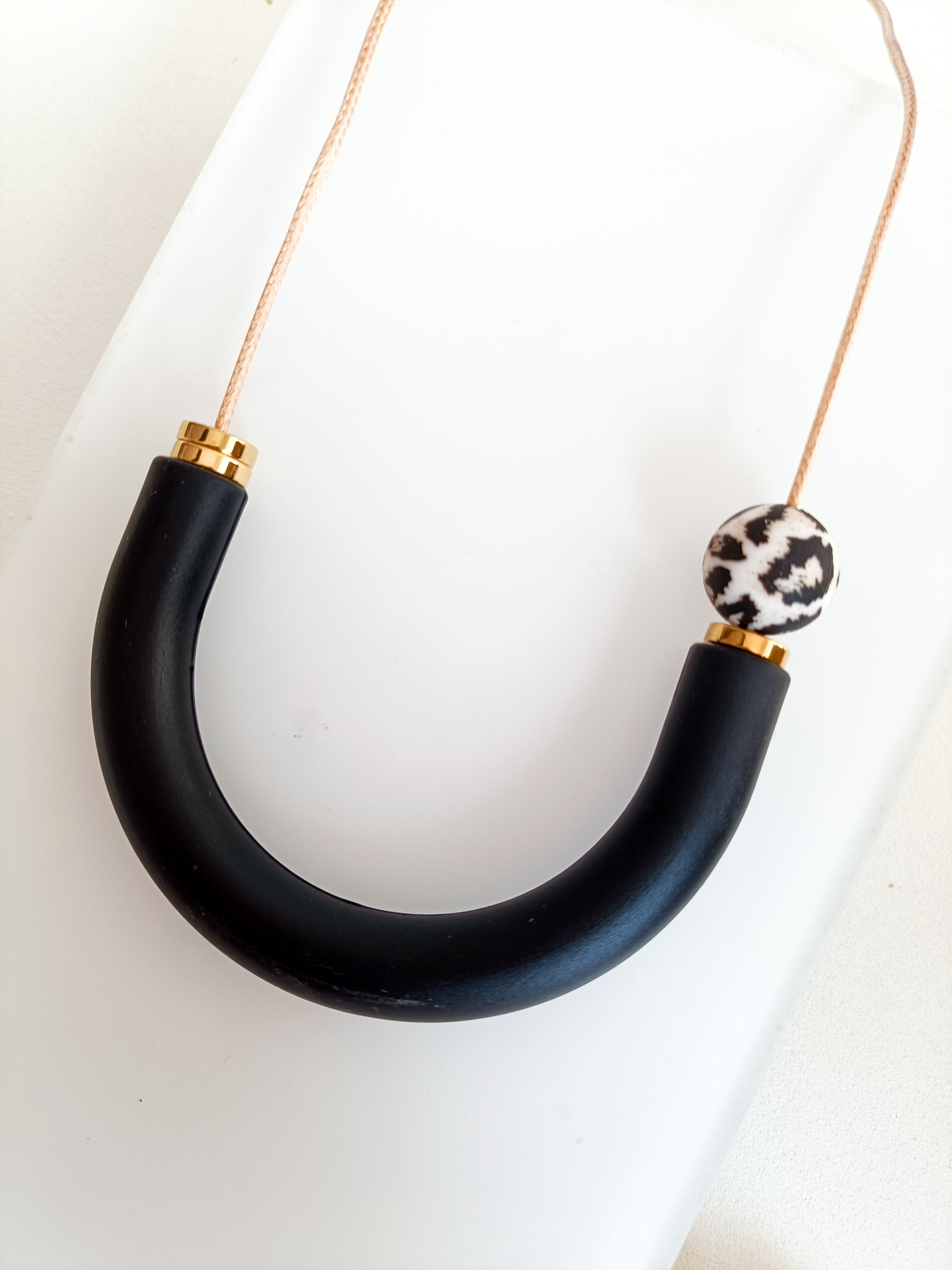 Leopard print breastfeeding necklace with teething ring in black and gold