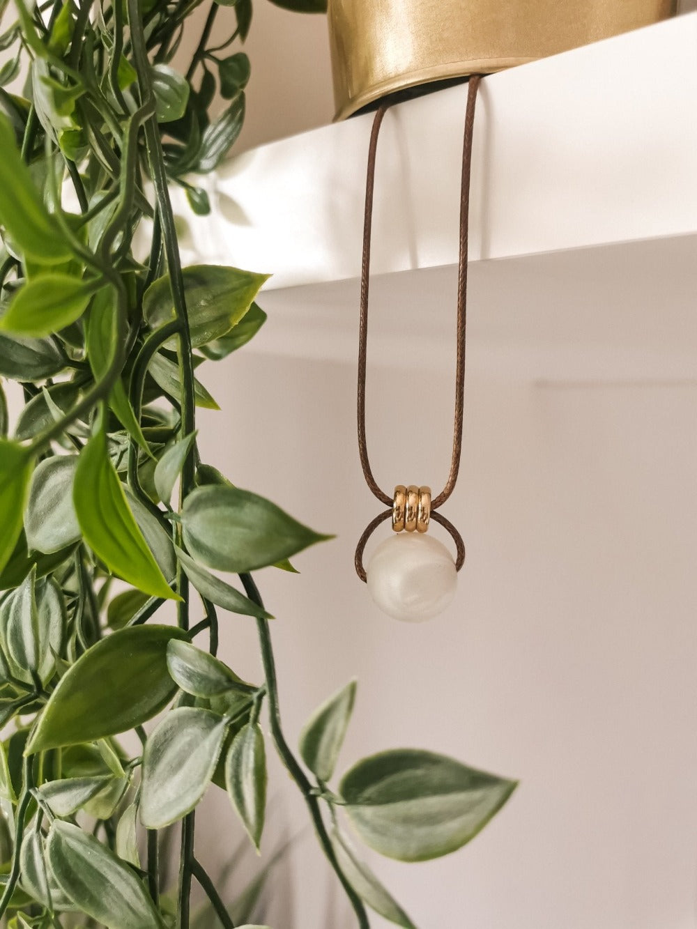 Antique Pearl breastfeeding and teething necklace ivory pearl white gold beads hanging on shelf