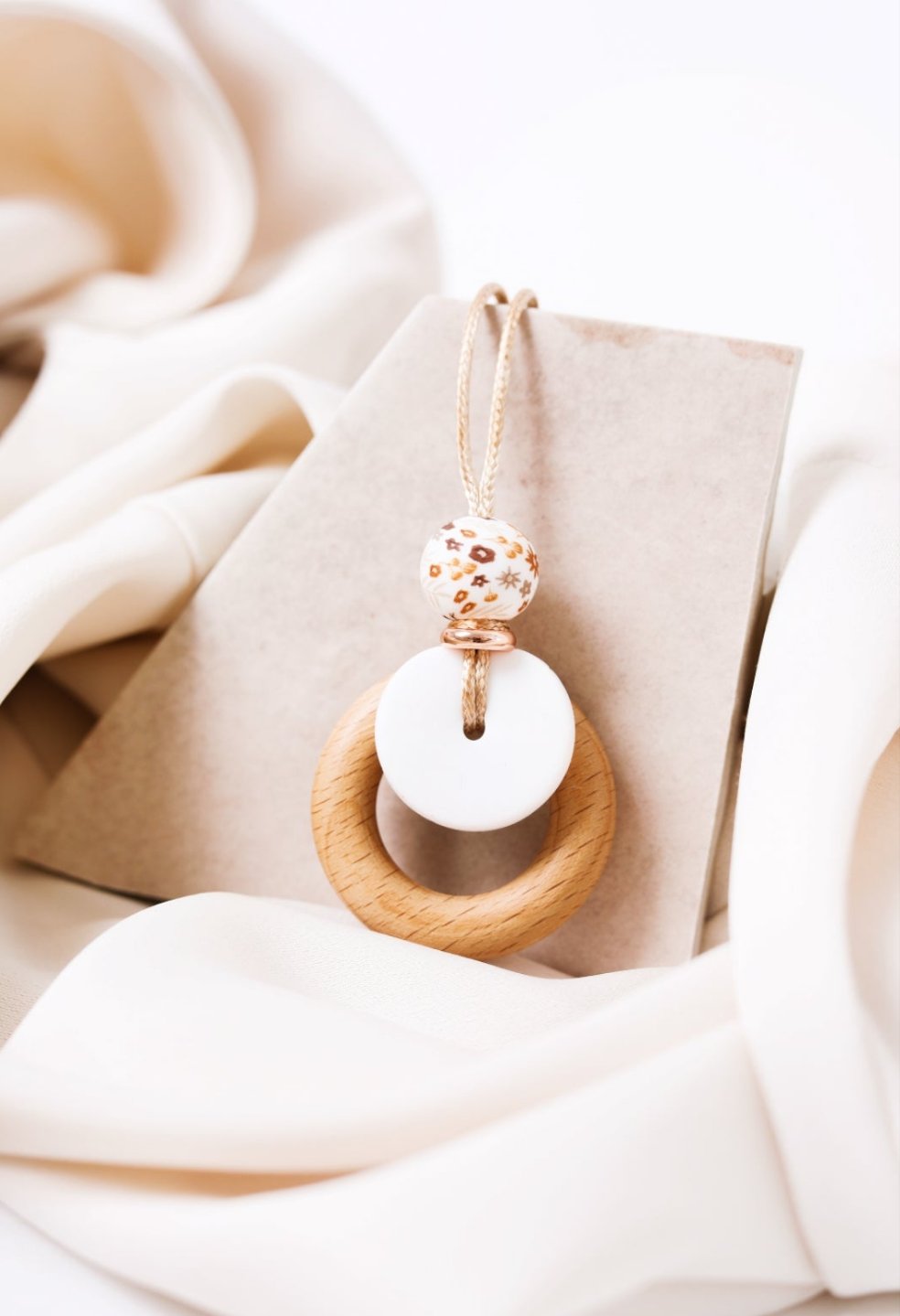 Autumn Blossom Pendant laid flat showing the chewable teething ring.