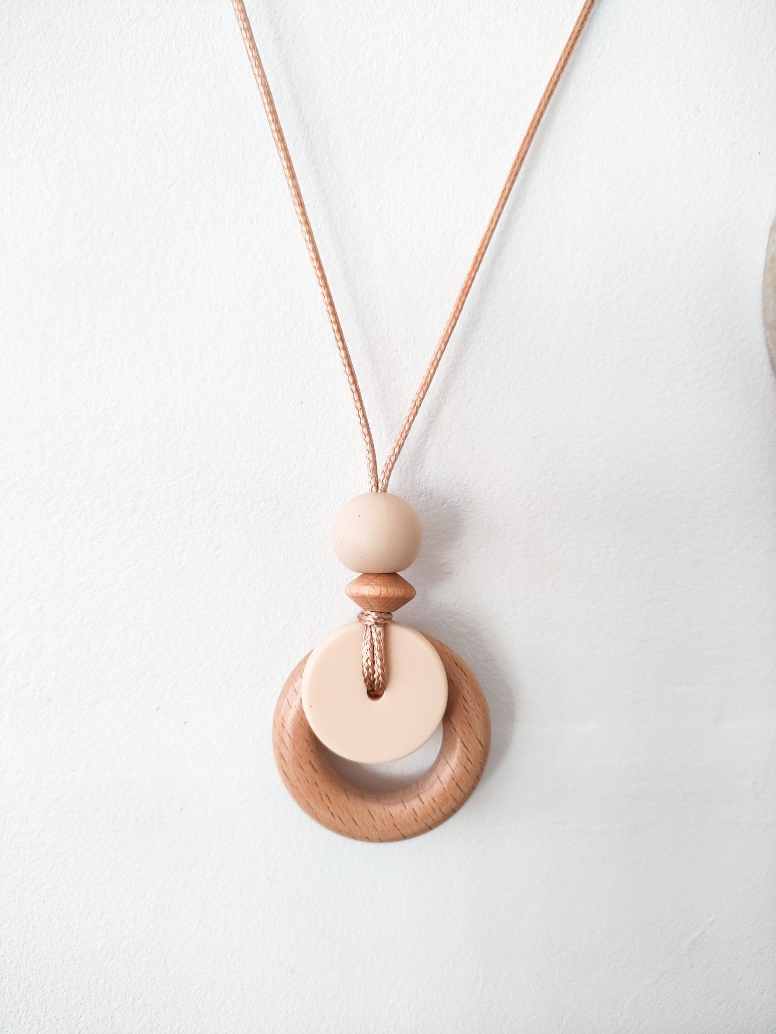 Cream breastfeeding pendant hung on white background