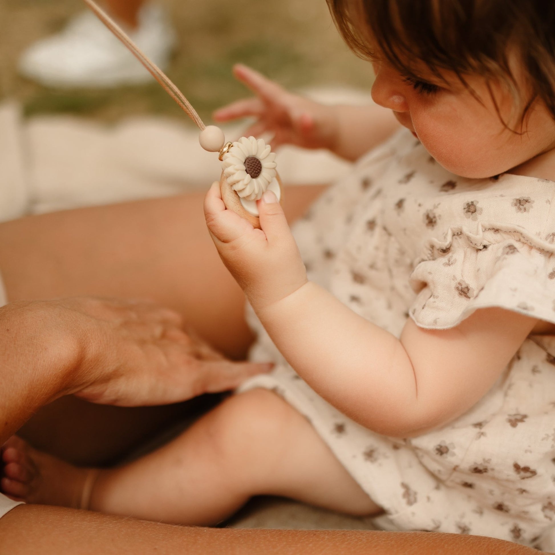Daisy Bloom Teething necklace being held by baby.-Blossy
