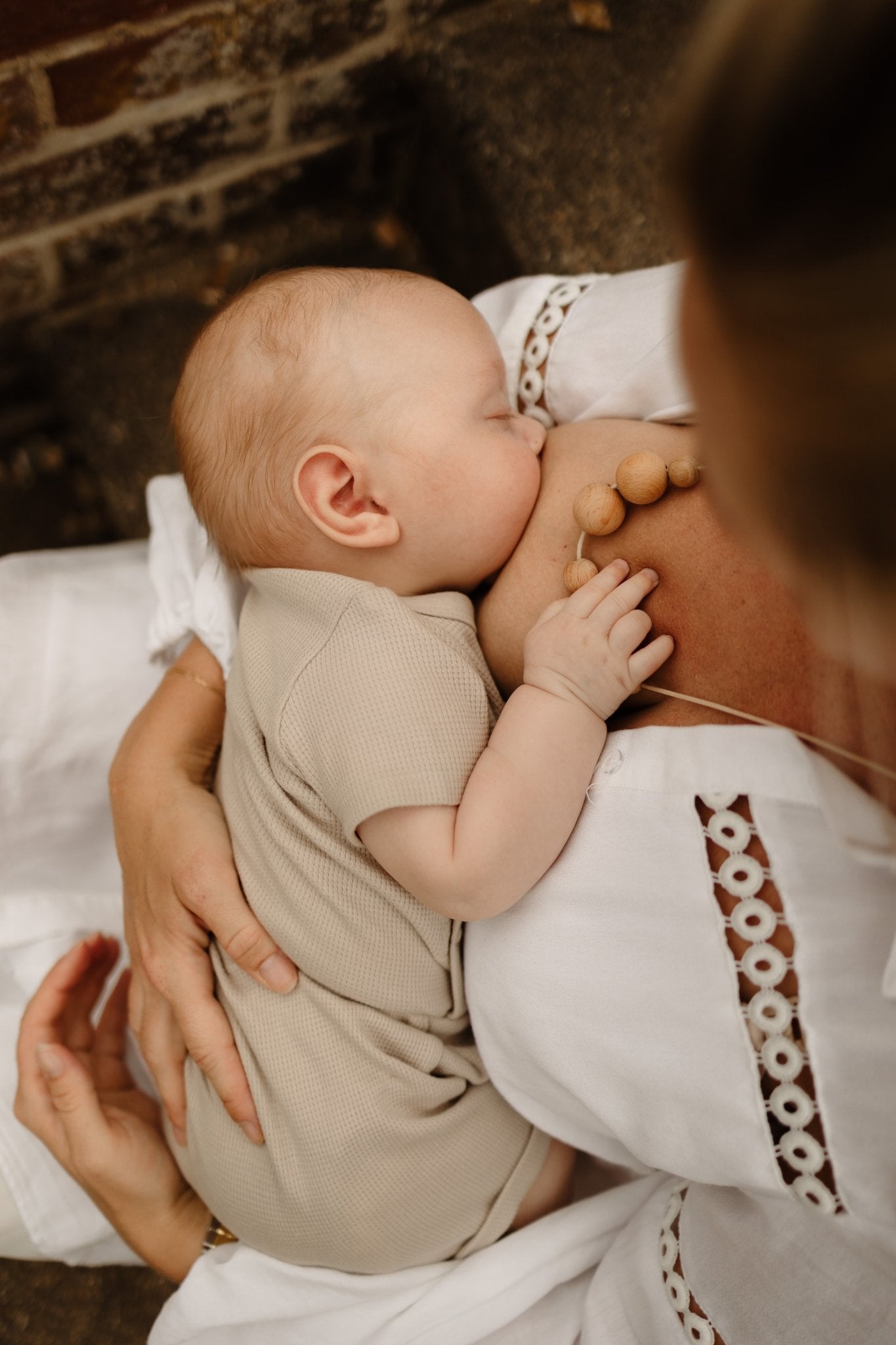 Naturals Beechwood Necklace worn by mum whilst breastfeeding baby holding it