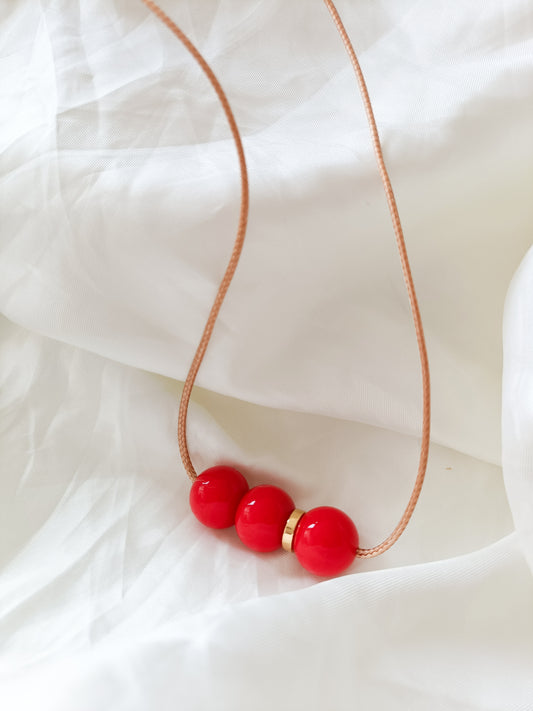 red bar necklace with gold detail, round red beads