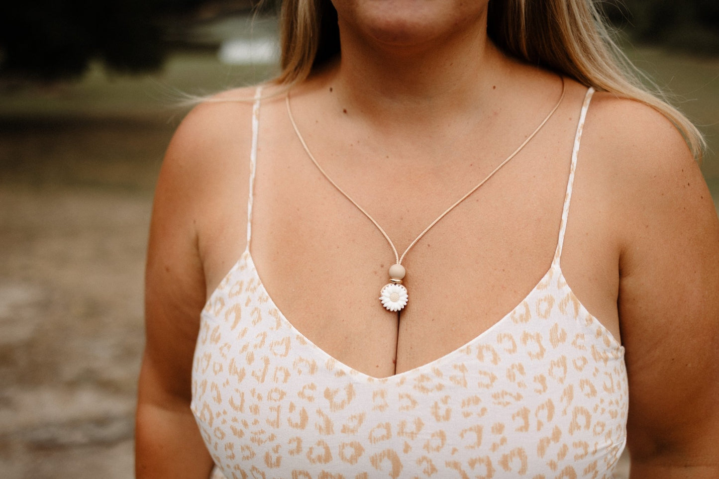 Dainty Daisy breastfeeding necklace in white worn by mum to keep small hands busy.- Blossy